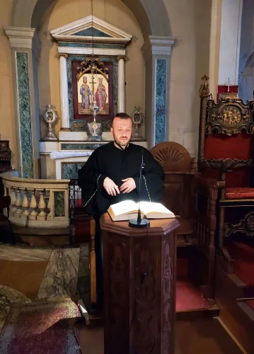 Petros Nikitas standing at a wooden analogion inside a church